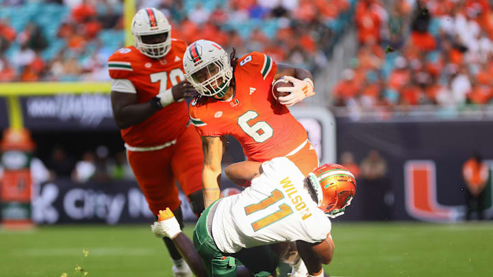 Sep 7, 2024; Miami Gardens, Florida, USA; Miami Hurricanes running back Damien Martinez (6) runs with the football against Florida A&M Rattlers defensive back Deco Wilson (11) at Hard Rock Stadium. Mandatory Credit: Sam Navarro-Imagn Images