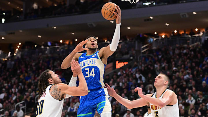 Feb 12, 2024; Milwaukee, Wisconsin, USA; Milwaukee Bucks forward Giannis Antetokounmpo (34) takes a shot between Denver Nuggets forward Aaron Gordon (50) and center Nikola Jokic (15) in the second quarter at Fiserv Forum. Mandatory Credit: Benny Sieu-Imagn Images