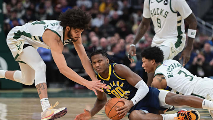 Dec 13, 2023; Milwaukee, Wisconsin, USA; Indiana Pacers center Bennedict Mathurin (00) battles for a loose ball against Milwaukee Bucks guard Andre Jackson Jr. (44) and guard MarJon Beauchamp (3) in the first quarter at Fiserv Forum. Mandatory Credit: Benny Sieu-Imagn Images