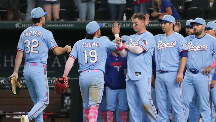 May 10, 2026; Arlington, Texas, USA; Texas Rangers first baseman Joc Pederson (3) points to center fielder Evan Carter (32) as he walks off the field after defeating the Chicago Cubs at Globe Life Field. Mandatory Credit: Raymond Carlin III-Imagn Images