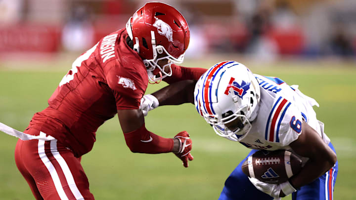Nov 23, 2024; Fayetteville, Arkansas, USA; Arkansas Razorbacks defensive back Jayden Johnson (8) tackles Louisiana Tech Bulldogs wide receiver Jimmy Holiday (6) during the fourth quarter at Donald W. Reynolds Razorback Stadium. Arkansas won 35-14. Mandatory Credit: Nelson Chenault-Imagn Images