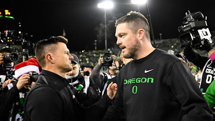 Dec 20, 2025; Eugene, OR, USA; James Madison Dukes head coach Bob Chesney and Oregon Ducks head coach Dan Lanning greet one another after the game at Autzen Stadium. 