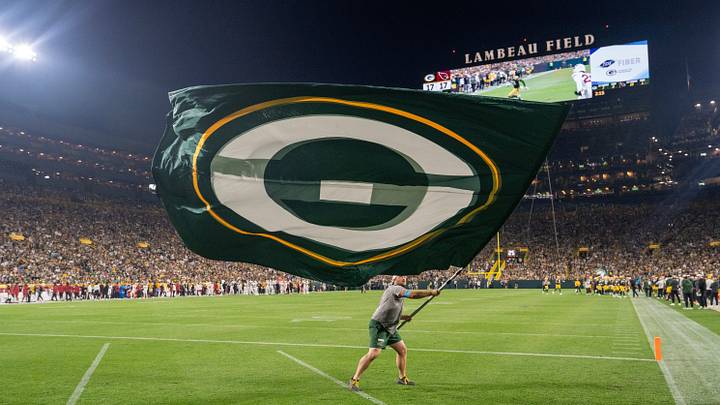 After a Green Bay Packers touchdown a man waves a flag in the end zone after a touchdown against Arizona. After a Green Bay Packers touchdown a man waves a flag in the end zone after a touchdown against Arizona.