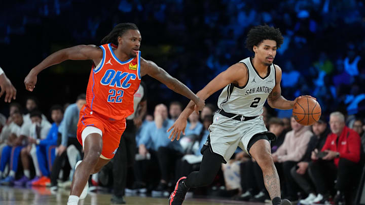 Dec 13, 2025; Las Vegas, Nevada, USA; San Antonio Spurs guard Dylan Harper (2) brings the ball up court as Oklahoma City Thunder guard Cason Wallace (22) defends during the third quarter at T-Mobile Arena. Mandatory Credit: Kirby Lee-Imagn Images
