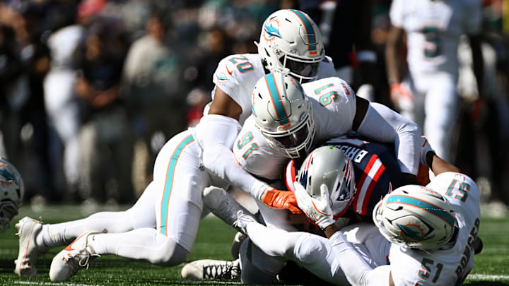 New England Patriots quarterback Jacoby Brissett (7) is sacked by linebacker Jordyn Brooks (20), linebacker Emmanuel Ogbah (91), and linebacker Tyus Bowser (51) during the first half at Gillette Stadium.