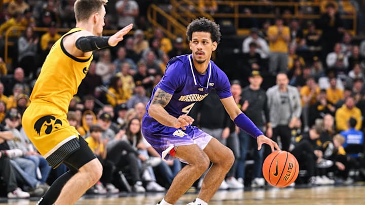 Feb 22, 2025; Iowa City, Iowa, USA; Washington Huskies guard DJ Davis (4) controls the ball as Iowa Hawkeyes guard Brock Harding (2) defends during the first half at Carver-Hawkeye Arena. Mandatory Credit: Jeffrey Becker-Imagn Images