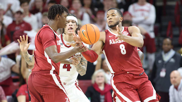 Feb 8, 2025; Fayetteville, Arkansas, USA; Arkansas Razorbacks forward Trevon Brazile (4) attempts to break up a pass to Alabama Crimson Tide guard Chris Youngblood (8) during the first half at Bud Walton Arena. Mandatory Credit: Nelson Chenault-Imagn Images