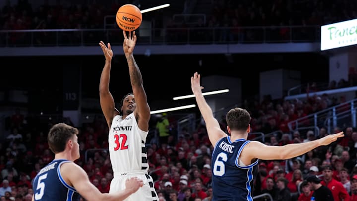 Mar 3, 2026; Cincinnati, Ohio, USA;  Cincinnati Bearcats forward Jalen Celestine (32) attempts a 3-point shot against BYU Cougars forward Mihailo Boskovic (5) and guard Aleksej Kostić (6) in the first half at Fifth Third Arena. Mandatory Credit: Aaron Doster-Imagn Images