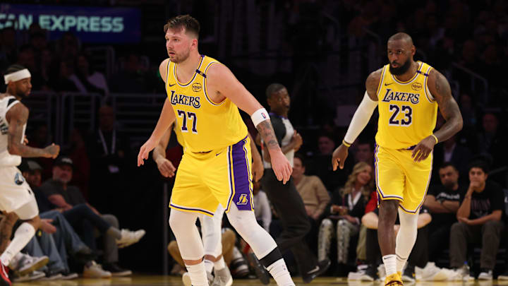 Feb 27, 2025; Los Angeles, California, USA; Los Angeles Lakers guard Luka Doncic (77) and forward LeBron James (23) defend during the second quarter against the Minnesota Timberwolves at Crypto.com Arena. Mandatory Credit: Jason Parkhurst-Imagn Images