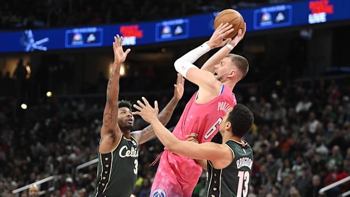 Mar 28, 2023; Washington, District of Columbia, USA; Washington Wizards center Kristaps Porzingis (6) looks to pass between Boston Celtics guard Malcolm Brogdon (13) and guard Marcus Smart (36) during the second half at Capital One Arena. Mandatory Credit: Brad Mills-Imagn Images