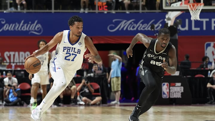 Jul 10, 2025; Las Vegas, NV, USA; Philadelphia 76ers Keve Aluma (27) dribbles past San Antonio Spurs forward David Jones-Garcia (25) in the second quarter of their game at Thomas & Mack Center. Mandatory Credit: Candice Ward-Imagn Images