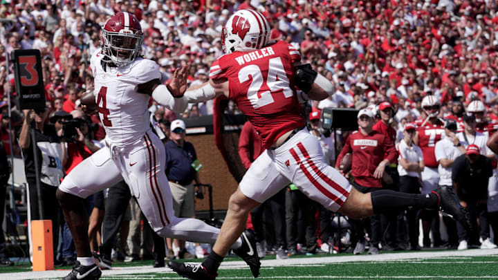 Alabama quarterback Jalen Milroe (4) scores a touchdown in 10-yard run despite the efforts of Wisconsin safety Hunter Wohler (24) during the third quarter of their game Saturday, September 14, 2024 at Camp Randall Stadium in Madison, Wisconsin.