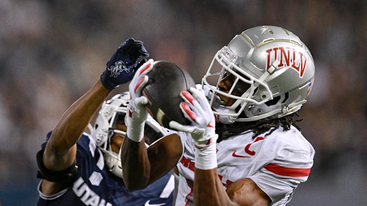 Former UNLV Rebels wide receiver Ricky White III (11) catches a touchdown pass in front of Utah State Aggies cornerback Avante Dickerson (17) in the first half at Merlin Olsen Field at Maverik Stadium. 