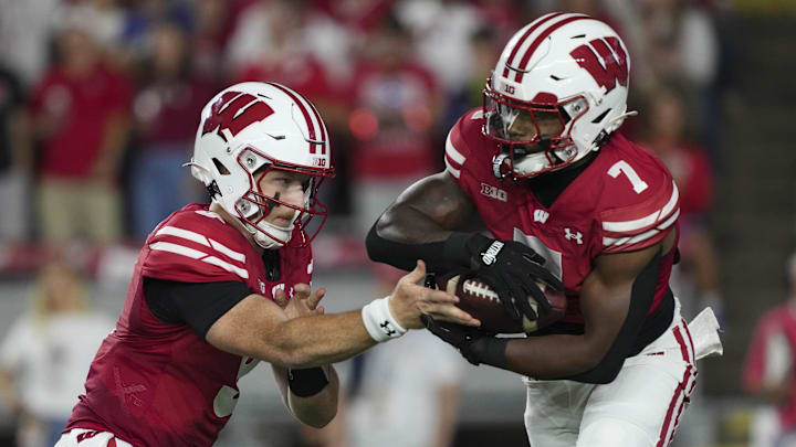 Aug 28, 2025; Madison, Wisconsin, USA;  Wisconsin Badgers quarterback Billy Edwards Jr. (9) hands the football off to running back Dilin Jones (7) during the first quarter against the Miami (OH) RedHawks at Camp Randall Stadium. Mandatory Credit: Jeff Hanisch-Imagn Images