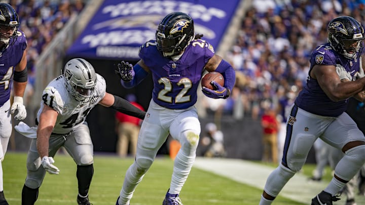 Sep 15, 2024; Baltimore, Maryland, USA;  Baltimore Ravens running back Derrick Henry (22) rushes by Las Vegas Raiders linebacker Robert Spillane (41) during the second half at M&T Bank Stadium. Mandatory Credit: Tommy Gilligan-Imagn Images