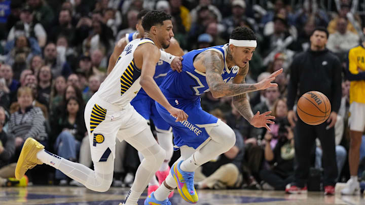 Mar 15, 2025; Milwaukee, Wisconsin, USA;  Milwaukee Bucks forward Kyle Kuzma (18) and Indiana Pacers guard Tyrese Haliburton (0) chase the loose ball during the fourth quarter at Fiserv Forum. Mandatory Credit: Jeff Hanisch-Imagn Images
