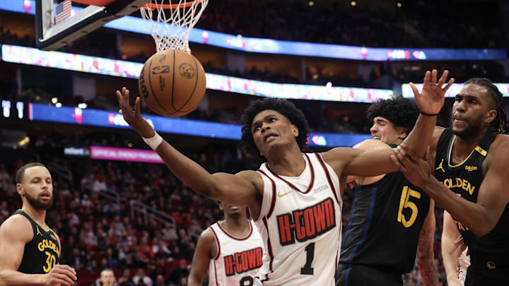 Feb 13, 2025; Houston, Texas, USA; Houston Rockets forward Amen Thompson (1) and Golden State Warriors forward Kevon Looney (5) reach for a rebound in the second  half at Toyota Center. Mandatory Credit: Thomas Shea-Imagn Images