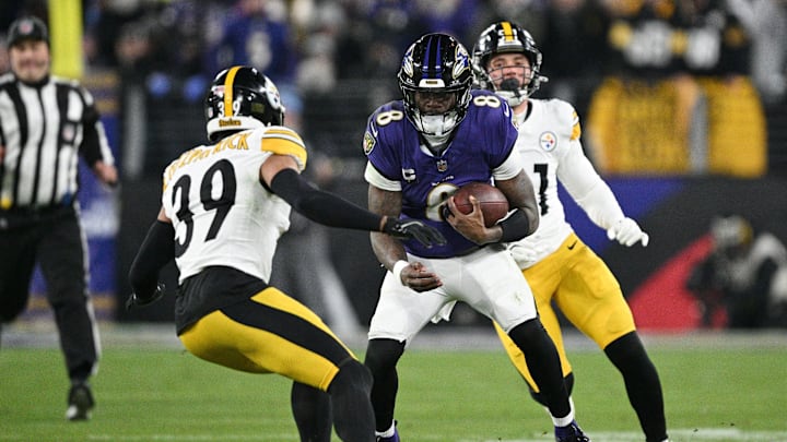 Jan 11, 2025; Baltimore, Maryland, USA; Baltimore Ravens quarterback Lamar Jackson (8) runs against Pittsburgh Steelers safety Minkah Fitzpatrick (39) and linebacker Nick Herbig (51) in the second quarter in an AFC wild card game at M&T Bank Stadium. Mandatory Credit: Tommy Gilligan-Imagn Images