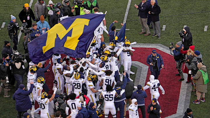 Michigan football players plant their team’s flag at midfield following Saturday’s NCAA Division I football game against the Ohio State Buckeyes at Ohio Stadium. The Michigan Wolverines won the game 13-10. Michigan football players plant their team’s flag at midfield following Saturday’s NCAA Division I football game against the Ohio State Buckeyes at Ohio Stadium. The Michigan Wolverines won the game 13-10.