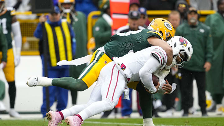 Oct 13, 2024; Green Bay, Wisconsin, USA;  Green Bay Packers safety Evan Williams (33) tackles Arizona Cardinals quarterback Kyler Murray (1) during the second quarter at Lambeau Field. Mandatory Credit: Jeff Hanisch-Imagn Images