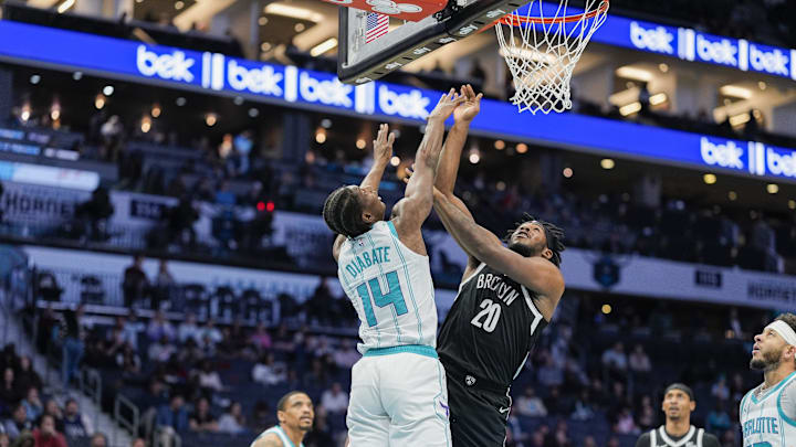 Jan 29, 2025; Charlotte, North Carolina, USA; Charlotte Hornets forward Moussa Diabate (14) tries to block a shot by Brooklyn Nets center Day'Ron Sharpe (20) during the first quarter at Spectrum Center. Mandatory Credit: Jim Dedmon-Imagn Images