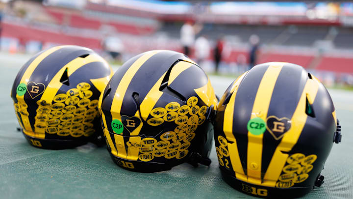 Dec 31, 2024; Tampa, FL, USA; Michigan Wolverines quarterback helmets sit on the field before a game against the Alabama Crimson Tide at Raymond James Stadium. Mandatory Credit: Matt Pendleton-Imagn Images