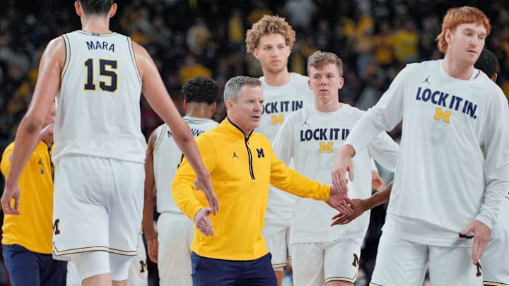 Michigan head coach Dusty May greets players as they come off the court for a time out during the second half of the NCAA national championship game against Connecticut at Lucas Oil Stadium in Indianapolis on Monday, April 6, 2026.