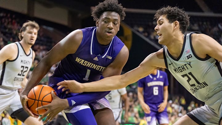 Oregon forward Brandon Angel, right, attempts to steal the ball from Washington forward Great Osobor as the Oregon Ducks host the Washington Huskies Tuesday, Jan. 21, 2025, at Matthew Knight Arena in Eugene, Ore.