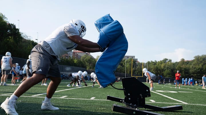 Kansas redshirt senior offensive lineman Enrique Cruz Jr. (77) pushes against a sled during practice at the Murfin Family Practice Fields on Aug. 8, 2025.