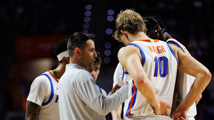 Florida Gators head coach Todd Golden talks with forward Thomas Haugh (10) and guard Xaivian Lee (1) and center Rueben Chinyelu (9).