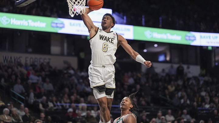 Jan 7, 2026; Winston-Salem, North Carolina, USA; Wake Forest Demon Deacons guard Myles Colvin (6) dunks the ball against Miami (FL) Hurricanes forward Shelton Henderson (7) during the first half at Lawrence Joel Veterans Memorial Coliseum. Mandatory Credit: Jim Dedmon-Imagn Images