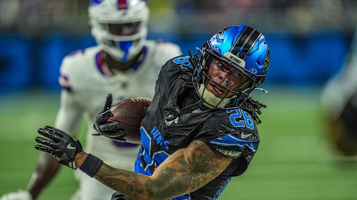 Detroit Lions running back Jahmyr Gibbs (26) tip toes along th sideline to get a first down on a back toss from Detroit Lions wide receiver Amon-Ra St. Brown (14) in a trick play iduring the second half at Ford Field in Detroit on Sunday, Dec. 15, 2024.