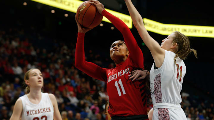 Sacred Heart's Zakiyah Johnson makes the basket against McCracken's Jayden Skaggs in the Mingua Beef Jerky Sweet 16 Girl's Basketball Championship. Mar. 16, 2024
