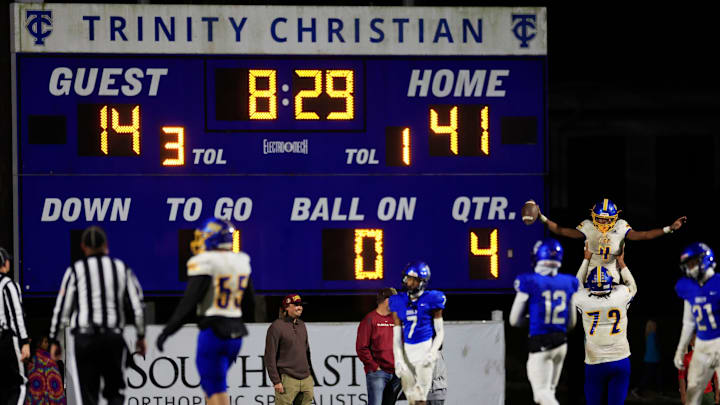 Orlando Christian Prep's Akeevin Anderson (4) scores a touchdown as Orlando Christian Prep's Demetrius Campbell (72) hoists him high during the fourth quarter of an FHSAA Region 1-1M high school football playoff matchup Friday, Nov. 24, 2023 at Trinity Christian Academy in Jacksonville, Fla. Trinity Christian Academy Conquerors defeated the Orlando Prep Warriors 48-20 and advance to the state semifinal. [Corey Perrine/Florida Times-Union]