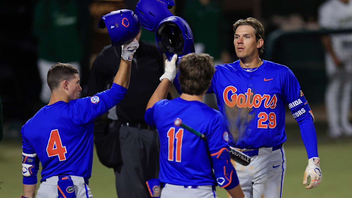 Florida catcher Brody Donay (29) taps helmets with infielder Cade Kurland (4) and infielder Brendan Lawson (11) after a solo home run during the fifth inning of an NCAA baseball matchup Monday, Feb. 17, 2025 at Jacksonville University in Jacksonville, Fla. Florida defeated Jacksonville 10-4. [Corey Perrine/Florida Times-Union]