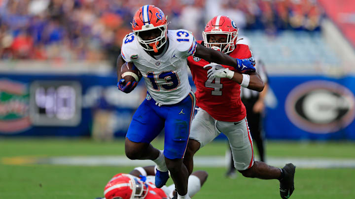 Florida Gators running back Jadan Baugh (13) fends off Georgia Bulldogs defensive back KJ Bolden (4) during the second quarter of an NCAA college football matchup Saturday, Nov. 2, 2024 at EverBank Stadium in Jacksonville, Fla. The Georgia Bulldogs defeated the Florida Gators 34-20. [Corey Perrine/Florida Times-Union]