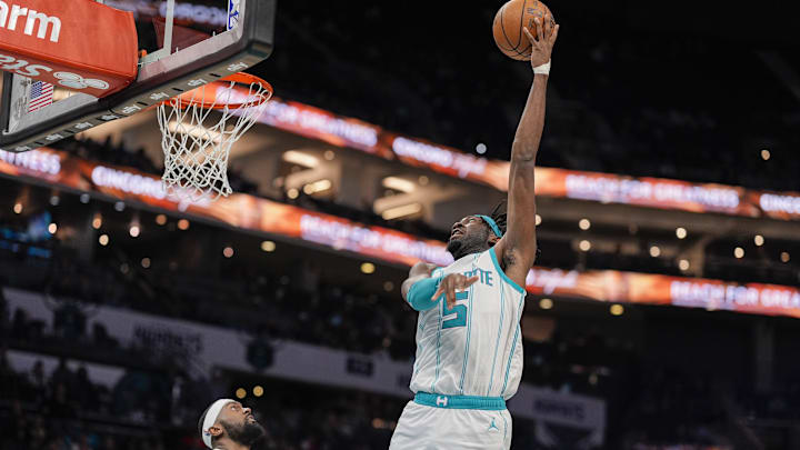 Feb 5, 2025; Charlotte, North Carolina, USA; Charlotte Hornets center Mark Williams (5) lays in the basket over Milwaukee Bucks forward Bobby Portis (9) during the second half at Spectrum Center. Mandatory Credit: Jim Dedmon-Imagn Images