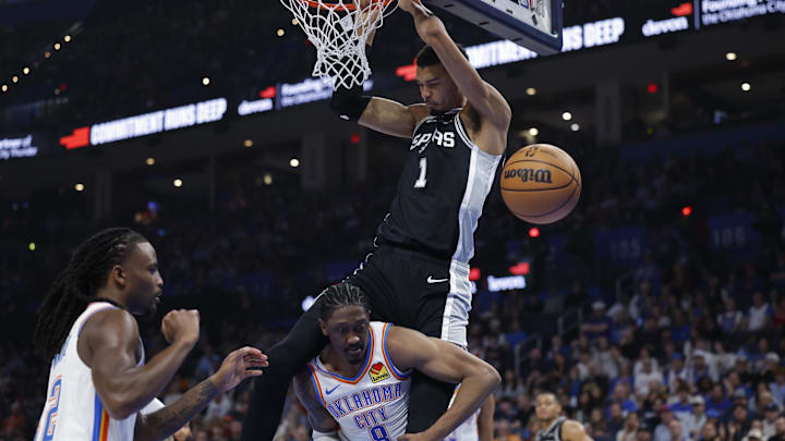 Dec 25, 2025; Oklahoma City, OK; Victor Wembanyama dunks over Jalen Williams during a game at Paycom Center