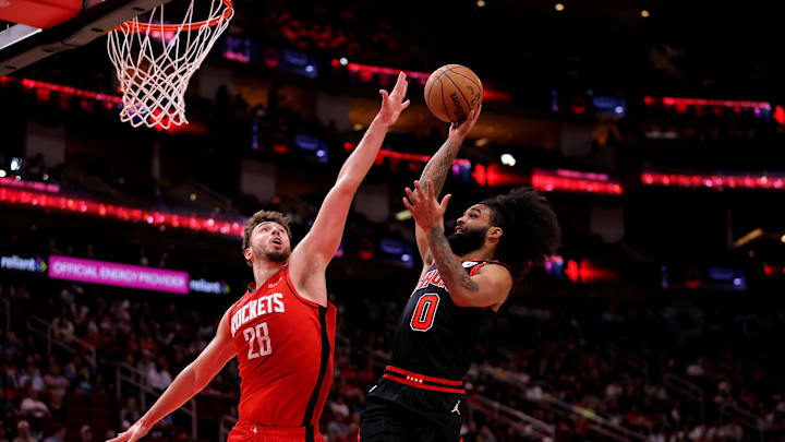 Mar 15, 2025; Houston, Texas, USA; Chicago Bulls guard Coby White (0) drives to the basket against Houston Rockets center Alperen Sengun (28) during the second quarter at Toyota Center. Mandatory Credit: Erik Williams-Imagn Images