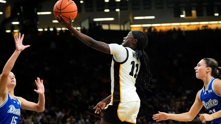 Iowa guard Chit-Chat Wright (11) drives to the basket against Drake forward Maggie Taylor (15), Nov. 13, 2025, at Carver-Hawkeye Arena in Iowa City, Iowa.
