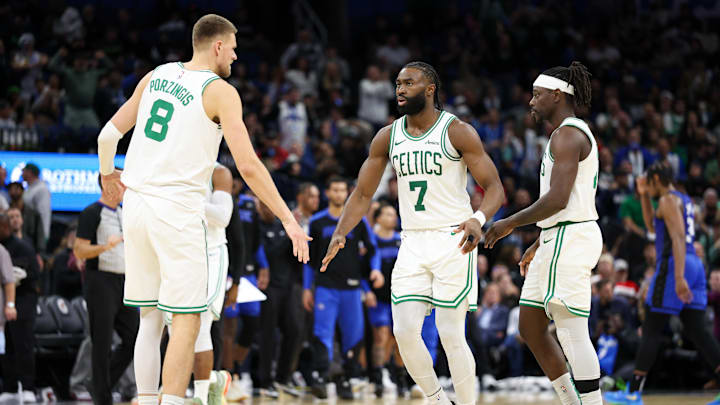 Dec 23, 2024; Orlando, Florida, USA; Boston Celtics guard Jaylen Brown (7) and center Kristaps Porzingis (8) celebrate after a basket against the Orlando Magic in the fourth quarter at Kia Center. Mandatory Credit: Nathan Ray Seebeck-Imagn Images