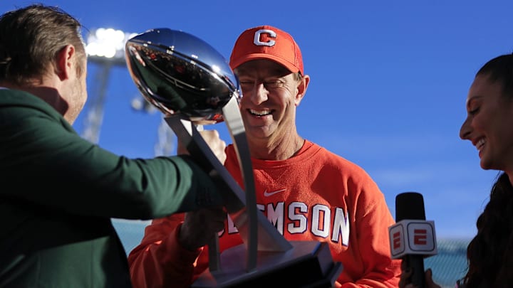 Clemson Tigers head coach Dabo Swinney admires the Ash Verlander Champions Trophy