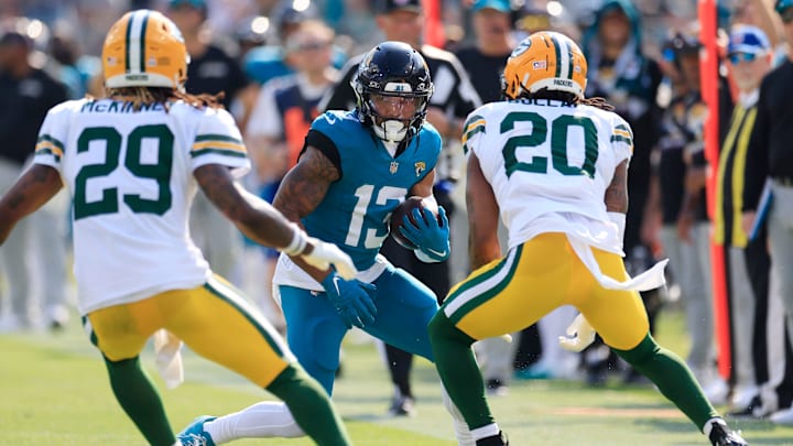 Jacksonville Jaguars wide receiver Christian Kirk (13) rushes for yards against Green Bay Packers safety Xavier McKinney (29) and safety Javon Bullard (20) during the third quarter of an NFL football matchup Sunday, Oct. 27, 2024 at EverBank Stadium in Jacksonville, Fla. The Packers edged the Jaguars 30-27 on a last-second field goal. [Corey Perrine/Florida Times-Union]