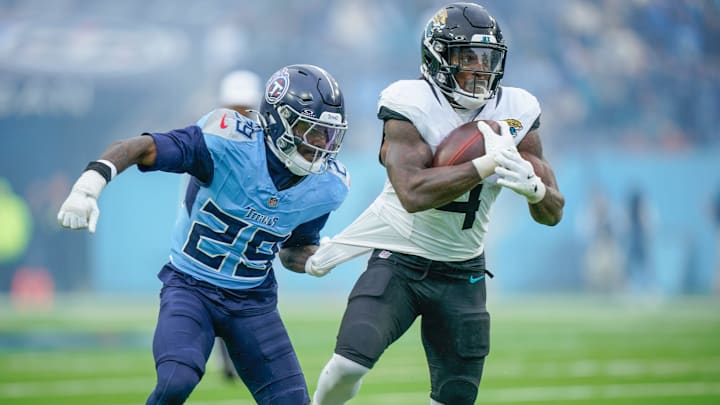 Tennessee Titans cornerback Jarvis Brownlee Jr. (29) grabs Jacksonville Jaguars running back Tank Bigsby (4) during the fourth quarter at Nissan Stadium in Nashville, Tenn., Sunday, Dec. 8, 2024.