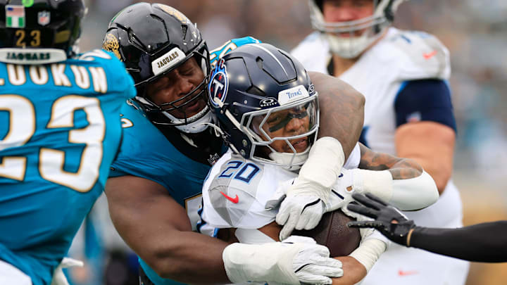 Tennessee Titans running back Tony Pollard (20) is tackled by Jacksonville Jaguars defensive tackle Davon Hamilton (52) during the first quarter of an NFL football matchup at EverBank Stadium, Sunday, Jan. 4, 2026, in Jacksonville, Fla. 