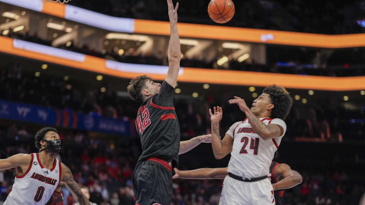 Mar 13, 2025; Charlotte, NC, USA; Stanford Cardinal forward Maxime Raynaud (42) blocks a shot by Louisville Cardinals guard Chucky Hepburn (24) during the second half at Spectrum Center. Mandatory Credit: Jim Dedmon-Imagn Images