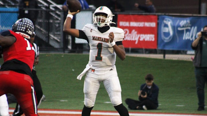 Mandarin quarterback Tramell Jones (1) prepares to toss a short pass over Miami Columbus pass rusher Willis McGahee IV (17) during the FHSAA Class 4M high school football championship game on December 8, 2023. [Clayton Freeman/Florida Times-Union]
