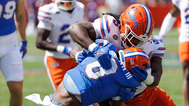 Apr 12, 2025; Gainesville, FL, USA; Florida Gators inside linebacker Myles Graham (5) tackles Florida Gators wide receiver Vernell Brown III (8) during the second half at Ben Hill Griffin Stadium. Mandatory Credit: Matt Pendleton-Imagn Images
