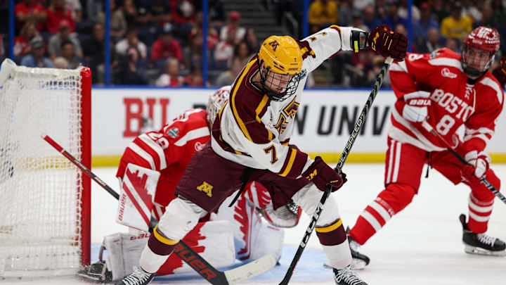 Apr 6, 2023; Tampa, Florida, USA; Minnesota forward Aaron Huglen (7) passes the puck between his legs for an assist on a goal against Boston University in the first period in the semifinals of the 2023 Frozen Four college ice hockey tournament at Amalie Arena. Mandatory Credit: Nathan Ray Seebeck-Imagn Images