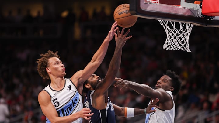 Nov 25, 2024; Atlanta, Georgia, USA; Atlanta Hawks guard Dyson Daniels (5) blocks the shot of Dallas Mavericks guard Kyrie Irving (11) as center Clint Capela (15) defends in the second quarter at State Farm Arena. Mandatory Credit: Brett Davis-Imagn Images
